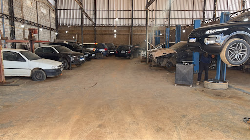 Vista interna da oficina com carros nos elevadores